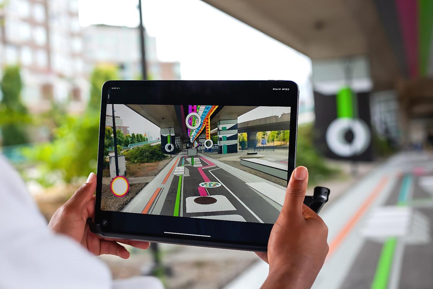 Estudante desenvolvendo aplicação AR em laboratório com múltiplos dispositivos